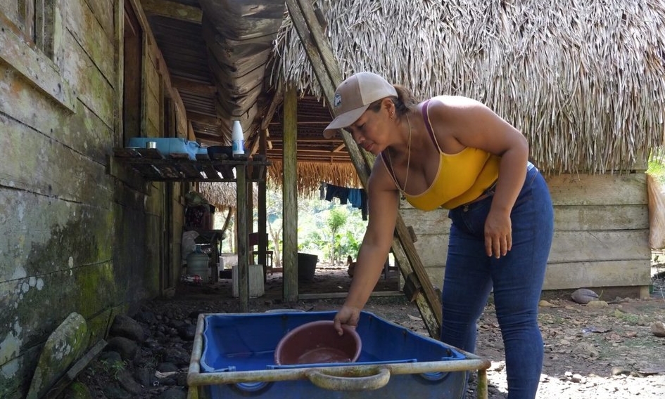 Elizabeth Delgado recoge agua de un tanque de almacenamiento en Limón de Chagres. Los habitantes de la comunidad se abastecen del río Indio, ya que no hay otra fuente de agua potable.|Pich Urdaneta / Diálogo Tierra