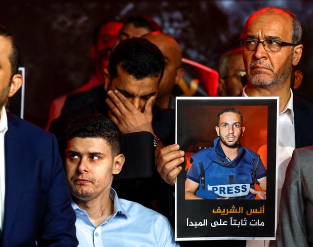 Un hombre sostiene una imagen de Anas al-Sharif mientras el personal se reúne en los estudios de Al Jazeera en Doha para recordar a sus colegas fallecidos en un ataque israelí en Gaza. Fotografía: Reuters
