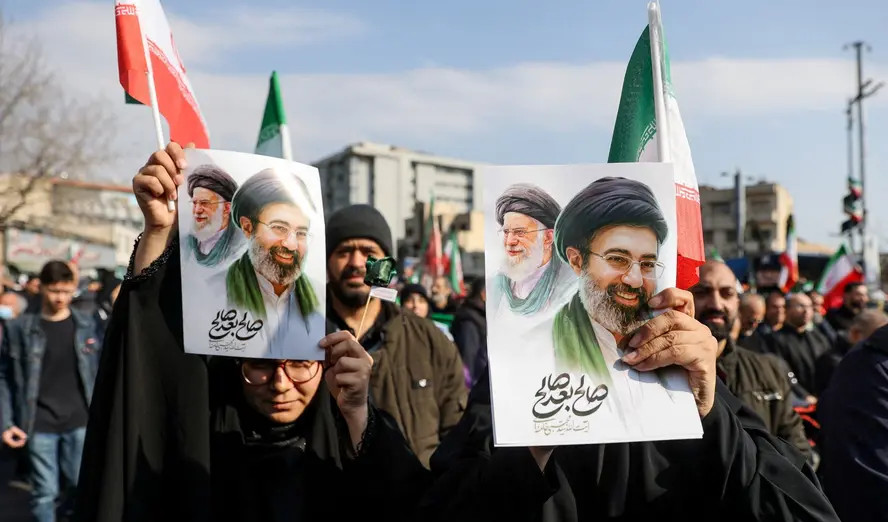 La gente sostiene carteles con una imagen del nuevo líder supremo de Irán, Mojtaba Khamenei, con su difunto padre, el ayatolá Ali Khamenei, en Teherán, Irán, el 9 de marzo de 2026. Fotografía de Majid Asgaripour/Agencia de Noticias de Asia Occidental vía Reuters