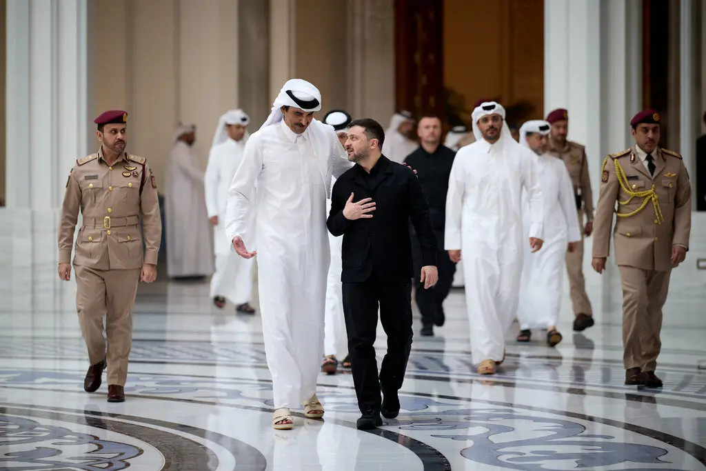 En una foto difundida por el Servicio de Prensa Presidencial de Ucrania, el presidente Volodímir Zelenski, de negro, y el emir de Catar, jeque Tamim bin Hamad al-Thani, en el centro a la izquierda, caminan juntos durante su reunión en Doha, Catar, el sábado.Credit...Servicio de Prensa Presidencial de Ucrania, vía Agence France-Presse