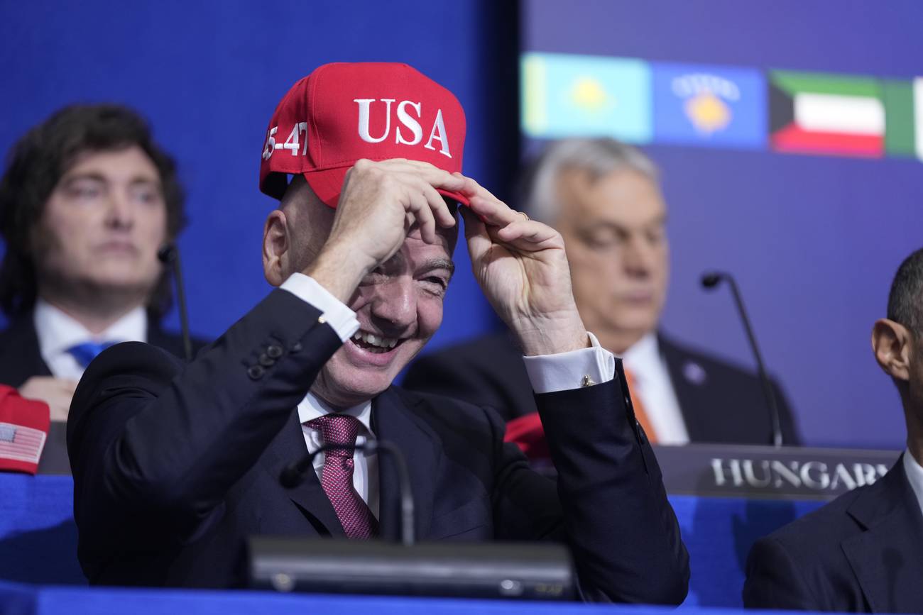 Gianni Infantino, presidente de la FIFA, se prueba una gorra de Estados Unidos durante una reunión de la Junta para la Paz impulsada por Donald Trump. (AP/Mark Schiefelbein)