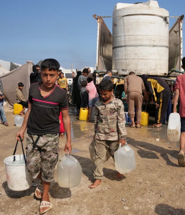 Niños palestinos desplazados recogiendo agua de un camión en un campamento de tiendas de campaña en Khan Yunis el 30 de abril. Crédito: Abdel Kareem Hana/AP