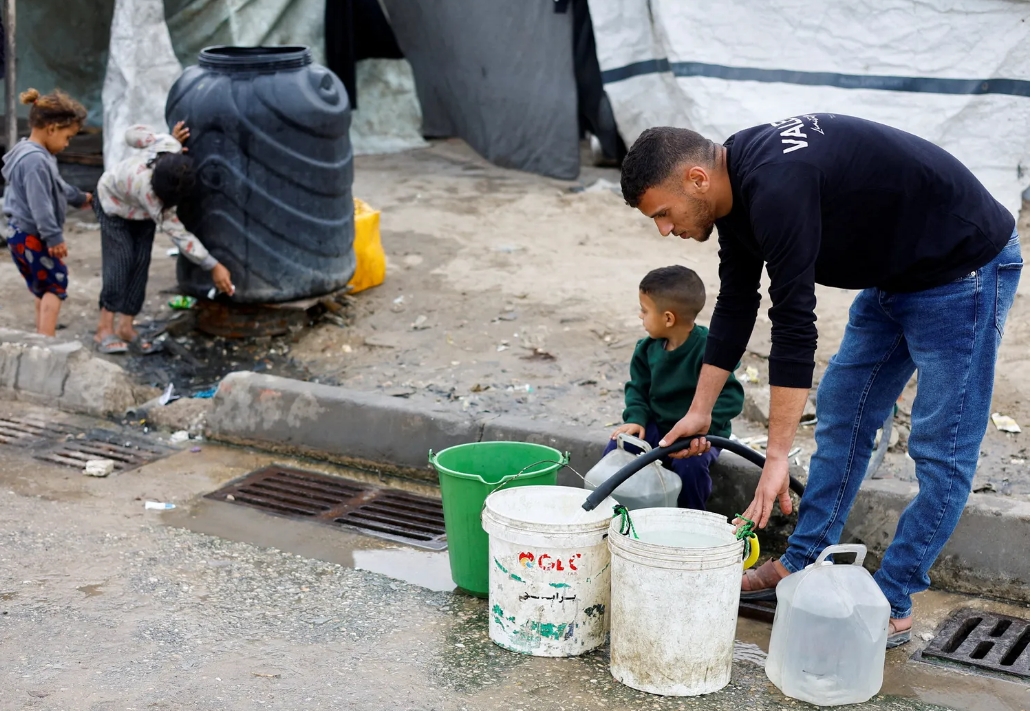 Un palestino llenando bidones de agua en Deir al-Balah el 24 de abril. Crédito: Mahmoud Issa/Reuters