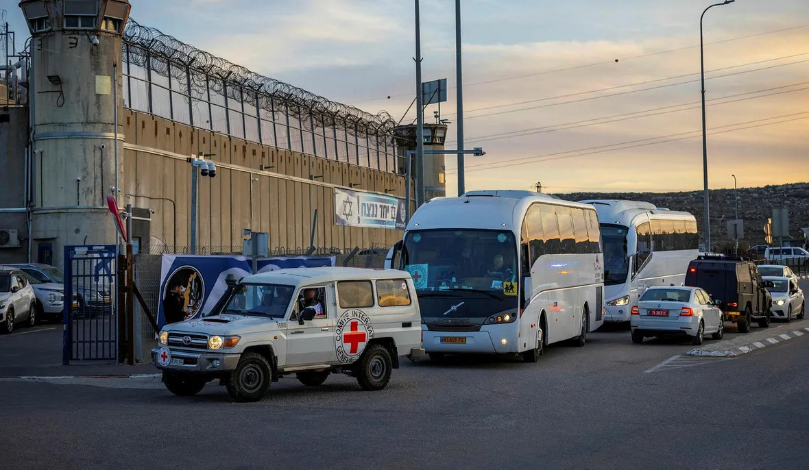 Un vehículo del CICR encabeza un convoy que transporta prisioneros palestinos liberados como parte de un intercambio de rehenes en las afueras de la prisión de Ofer, en Cisjordania, en 2025. Crédito: Olivier Fitoussi