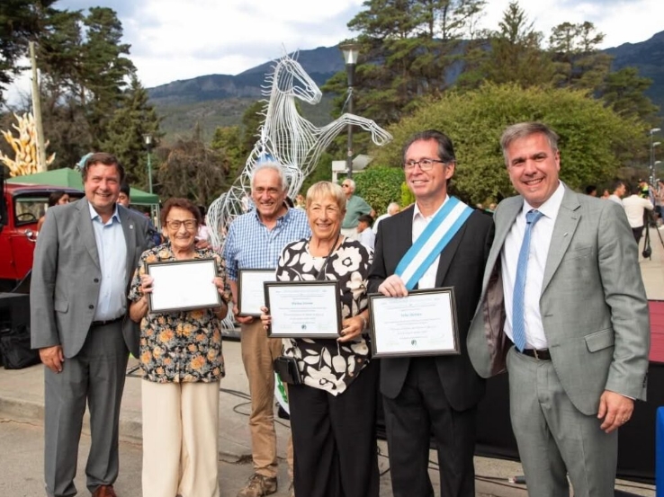 Foto del aniversario de el Bolsón del 28 de enero del 2026. Se lo ve al gobernador Alberto Weretilneck, al intendente Bruno Pogliano y el hijo de Félix Argentino Merino, el abanderado.