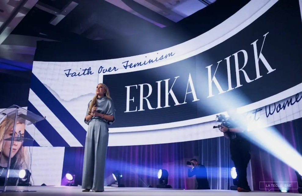 Foto: Erika Kirk durante la apertura de la Cumbre de Liderazgo Femenino, a la que asistieron alrededor de 3.000 mujeres. A sus espaldas, la pantalla proyecta su nombre y la leyenda “Faith over feminism” (La fe por encima del feminismo). Crédito: Revista Rolling Stone.