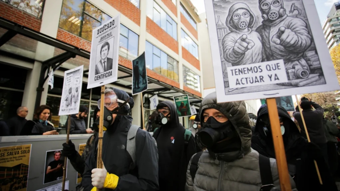 Científicos argentinos portan mascaras de gas para denunciar recorte al presupuesto de ciencia. Foto: RAICYT.