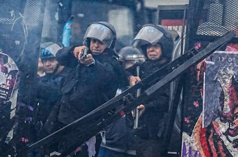 Un oficial de la PFA apunta contra el fotoperiodista Guido Piotrkowski. Guido Piotrkowski