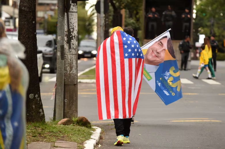 Un simpatizante de Flávio Bolsonaro sostiene una bandera de Estados Unido. EFE. EFE